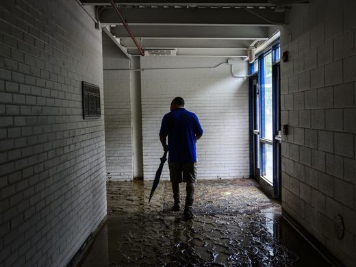 Herbert Hoover High School Principal Mike Kelley walks through hallway filled with slick mud in Clendenin, WV - Sam Owens