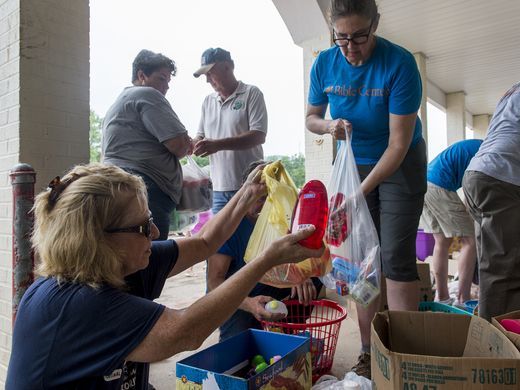 Karen Myers and Lisa Turley hand out donated items in the Smith's FoodFair parking lot in Clendenin, WV - Sam Owens