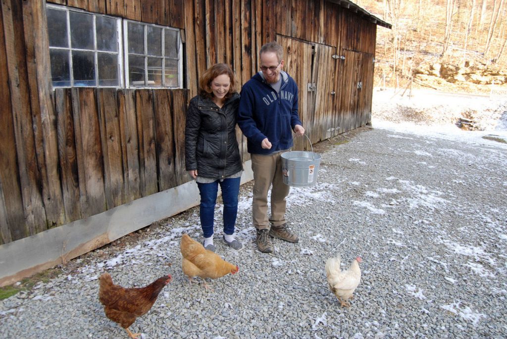 Angela and John Born feed the chickens at their Country Road House and Berries bed and breakfast and farm near Clendenin by Ben Calwell.