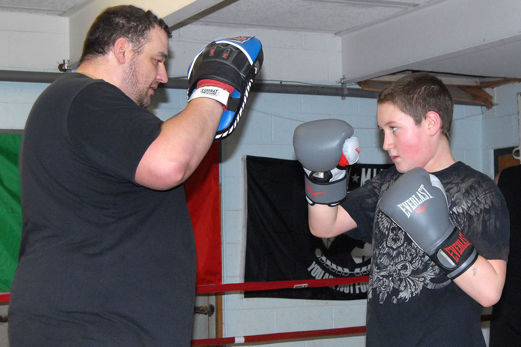 Wesley Fisher, right, of Elkview, spars with Brad Mullins at the Elk River Boxing Club's new Elkview location. At right, Emilee Morgan of Walton strikes a boxer's pose. Ben Calwell | Metro
