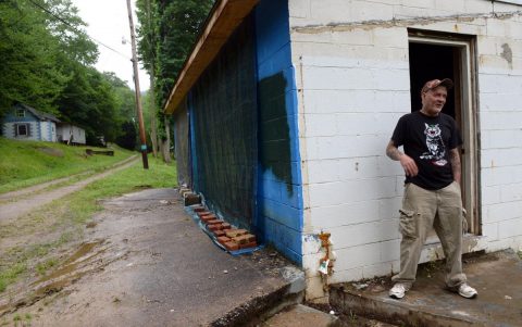 Mike Cahill stands outside of his garage-home in Procious. Cahill said he's lived there and at his mother's home since the June 2016 flood. A state program called RISE has been no help, he said. State officials have called for an investigation into the program.